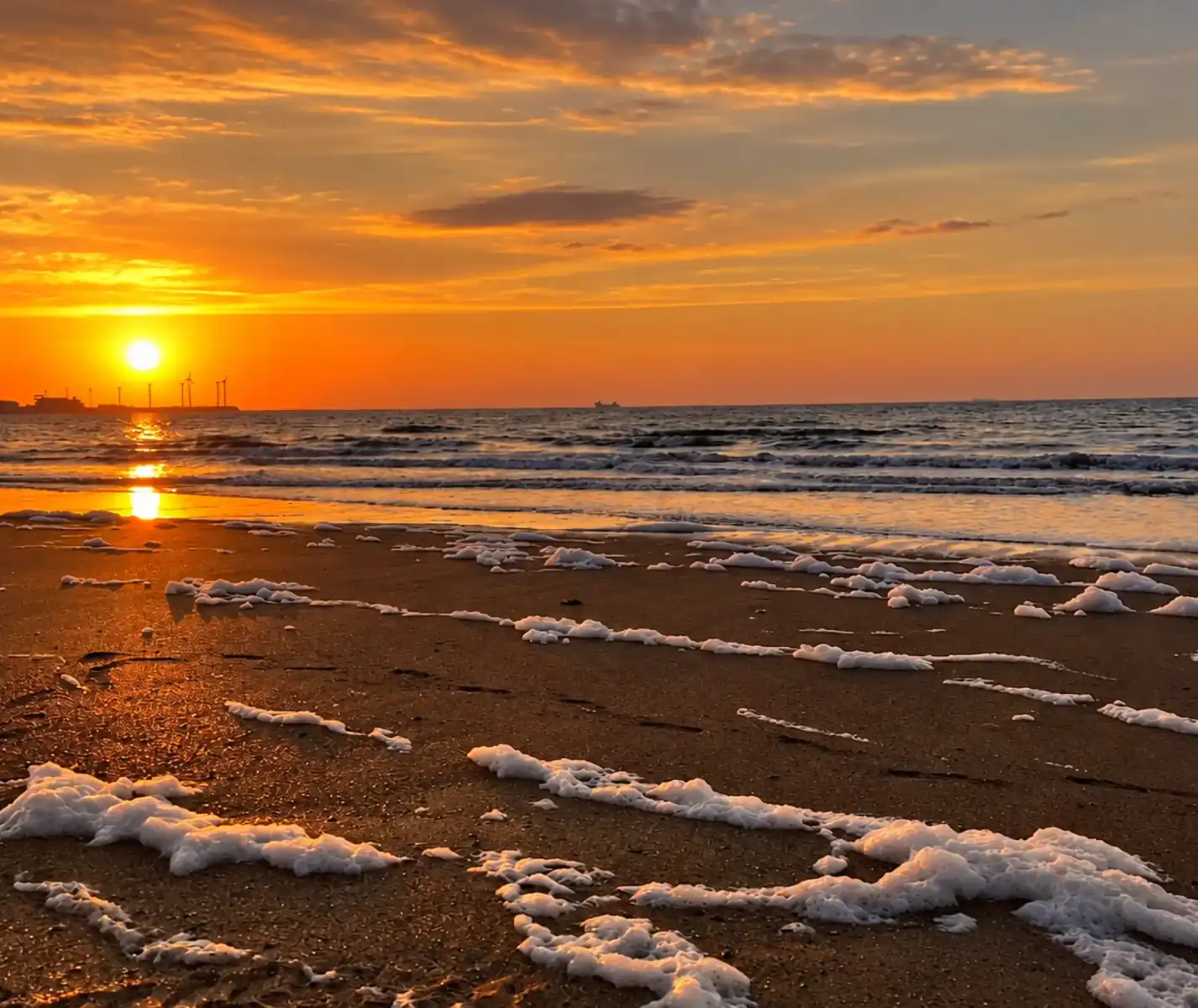 Zonsondergang boven de zee en een zandstrand