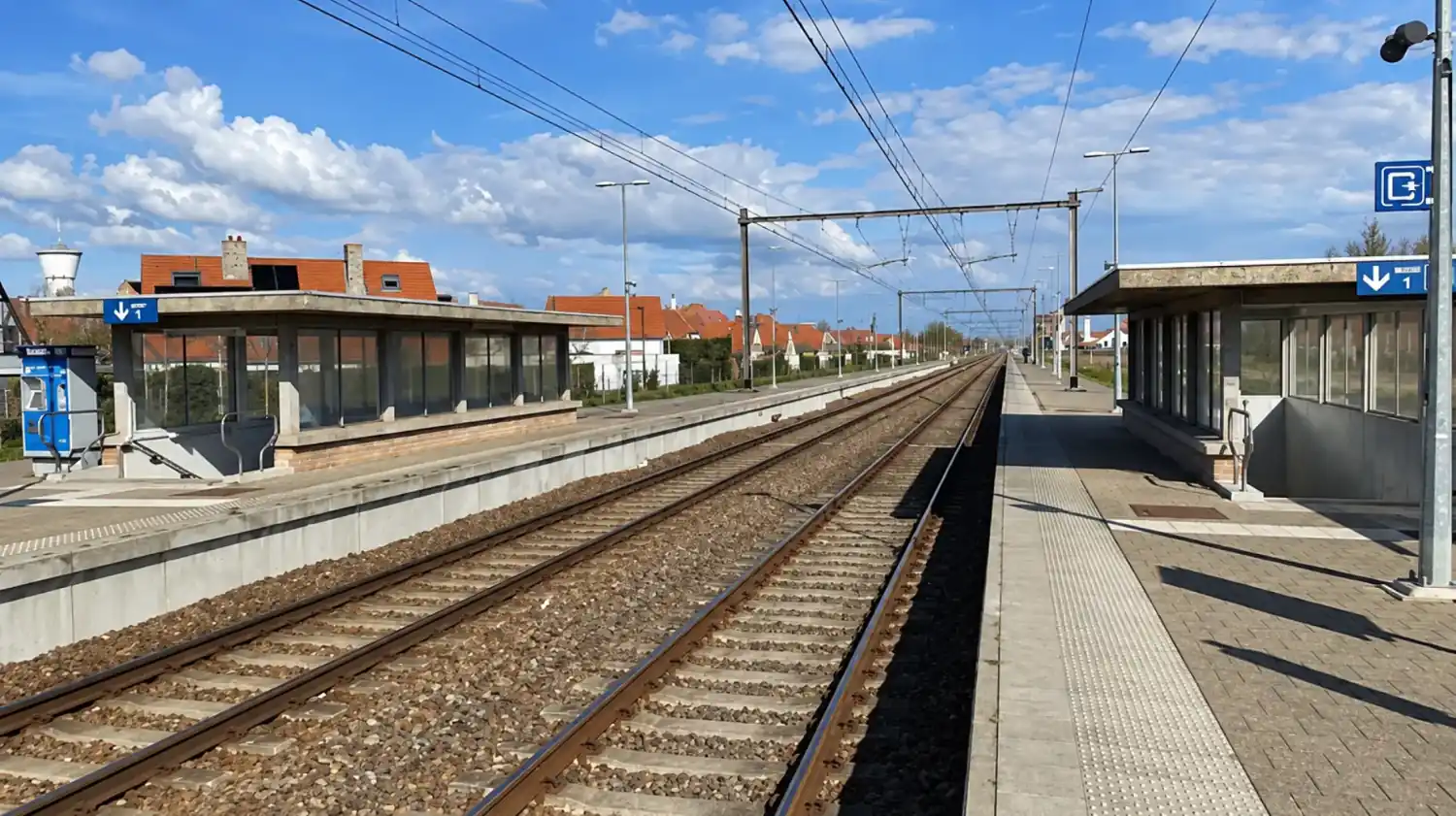 Treinstation met perrons, wachthuisjes en bovenleidingen